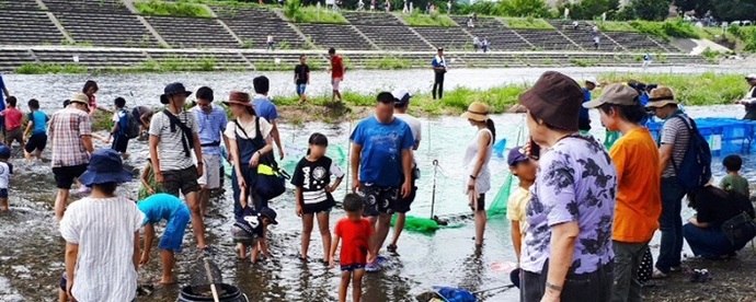 写真:ふれあい橋の下にて、家族が集まって釣りをしている