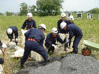 写真:土のうを作る団員