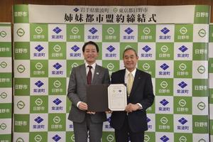 写真:締結書を二人で持つ日野市市長と紫波町代表者