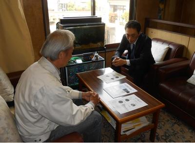 写真:コーディネーターが企業代表者に資料を見せている様子