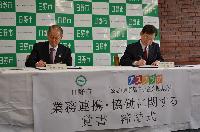 写真:締結の書面にサインする代表者の様子