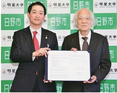 写真:締結書掲げる代表者ふたり