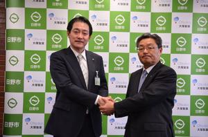 写真:スーツ姿で握手する市長と支店長