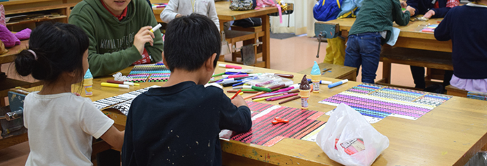 写真:紙の甲冑をデコる子供たち