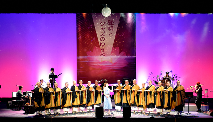 写真:ミラーボールの光を浴びながら「いつも何度でも」を演奏するジャズバンドと僧侶たち