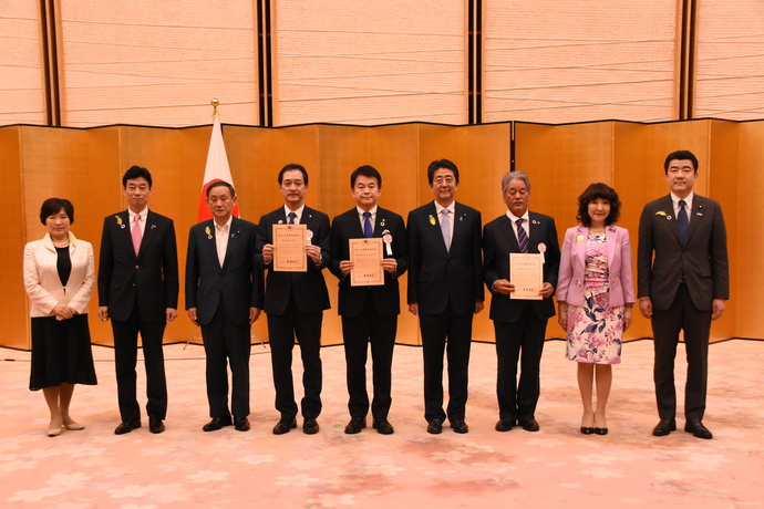 写真:選定証を交付される日野市長