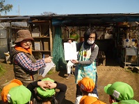 せせらぎ農園で種いもの植え方の説明を聞いている写真