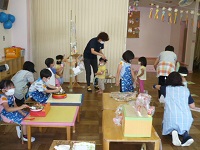 4歳児ぞう組のお店屋さんに2歳児うさぎ組が来ている写真