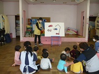 1歳児りす組がはたらくくるまのパネルシアターを見ている写真