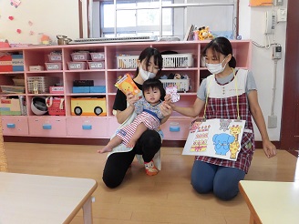 0歳児（ひよこ組）の誕生日のお祝いを『いないいないばぁ』のパネルシアターでしているところの写真