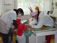 1歳児りす組が遠足ごっこでウサギに餌をあげている写真