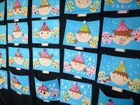 3歳児こあら組の作った帽子と手袋を着けた自分の写真