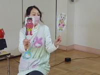 豆まきのペープサートを行う保育士の写真