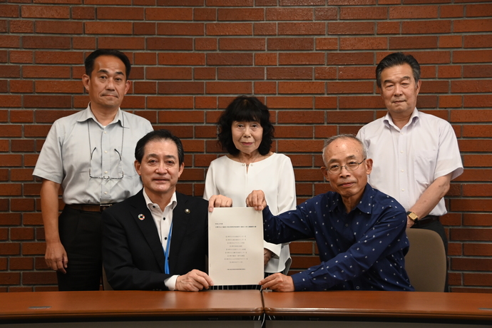 写真:市民委員より市長へ報告書手渡し