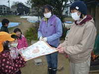 5歳児らいおん組がせせらぎ農園の方にお礼のメッセージを渡している写真