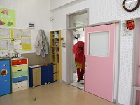 鬼がドアから0歳児室を覗いている写真です。