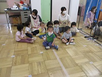 1歳児誕生児が誕生会に初めて参加している写真です。