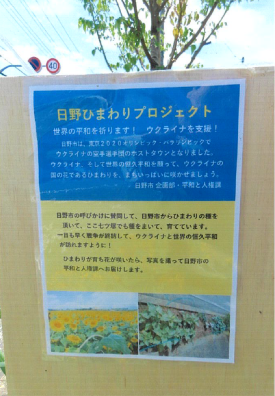 看板の写真(日野ひまわりプロジェクト世界の平和を祈ります!ウクライナを支援!日野市は、東京2020オリンピックパラリンピックでウクライナの空手選手団のホストタウンとなりました。ウクライナ、そして世界の恒久平和を願って、ウクライナの国の花であるひまわりを、まちいっぱいに咲かせましょう。日野市の呼びかけに賛同して、日野市からひまわりの種を頂いて、七つ塚でも種をまいて、育てています。一日も早く戦争が終結して、ウクライナと世界の恒久平和が訪れますように!ひまわりが育ち花が咲いたら、写真を撮って日野市の平和と人権課へお届けします。)