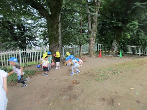 園庭でセミの抜け殻を探している子供達の様子の写真