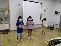 5歳児が誕生カードを見せている写真です。