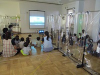 8月の誕生会であつあつお化けのDVDを見ている写真です。