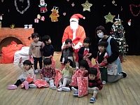 写真:サンタクロースと写真を撮る1歳児