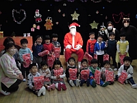 写真:サンタクロースと写真を撮る3歳児