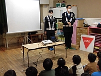 写真:おまわりさんと挨拶をする子どもたち