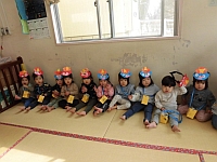 写真:1歳児鬼のお面をかぶっている様子