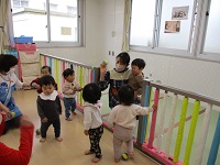 0歳児が豆まきをしている写真です。