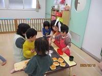 1歳児がパン屋さんごっこを楽しんでいる写真です。