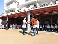 写真:卒園児プレゼントをもらう担任の先生の様子