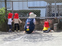 1歳児クラスが園庭から外を眺めている写真です。