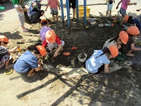 3歳児が泥んこ遊びをしている様子の写真です。