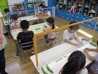 4歳児がそら豆の皮をむいている写真です。