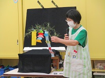 各クラスの飾りの紹介をする保育士の写真