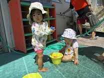 水遊びをする0歳児の写真1