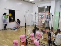 保育士からのプレゼント、パネルシアターをみている写真です。