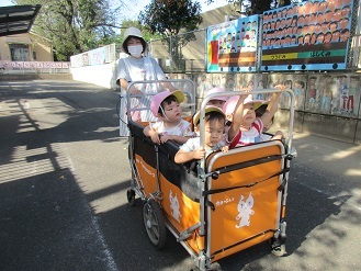 1歳児バギーにのって遠足に行く様子の写真