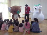 環境学習でエコアラとエコクマが話をしている様子の写真