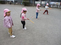 2歳児が羽根つきをしている写真です。