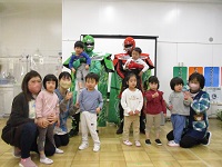 2歳児クラスがごみゼロマンと写真を撮っている写真です。