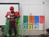 環境学習でごみゼロマンが来てゴミの分別について話をしている写真です。