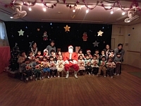 写真:サンタさんと一緒に写真撮影する3歳児