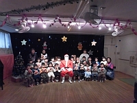 写真:サンタさんと一緒に写真撮影する4歳児