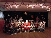 写真:サンタさんと一緒に写真撮影する5歳児