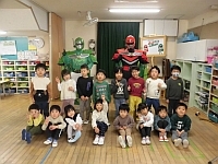 写真:ごみゼロマンと一緒に写真撮影する3歳児