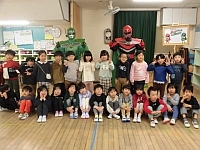 写真:ごみゼロマンと一緒に写真撮影する5歳児