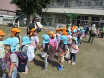 リュックを背負って、園庭に並んだ4，5歳児の写真