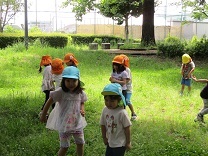 追いかけっこをして遊ぶ子どもの写真